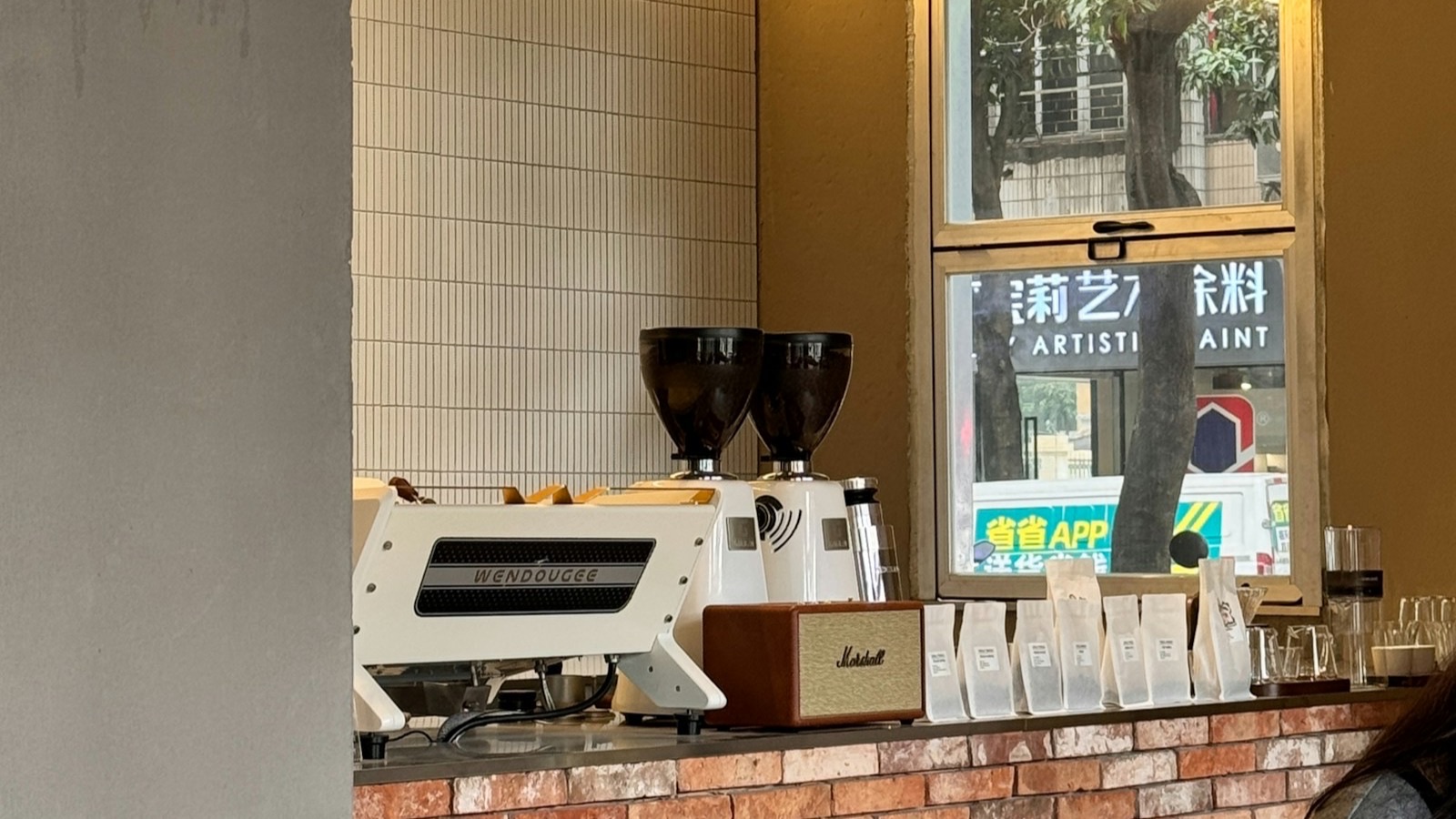 An espresso machine and grinders on the counter of a small coffee shop