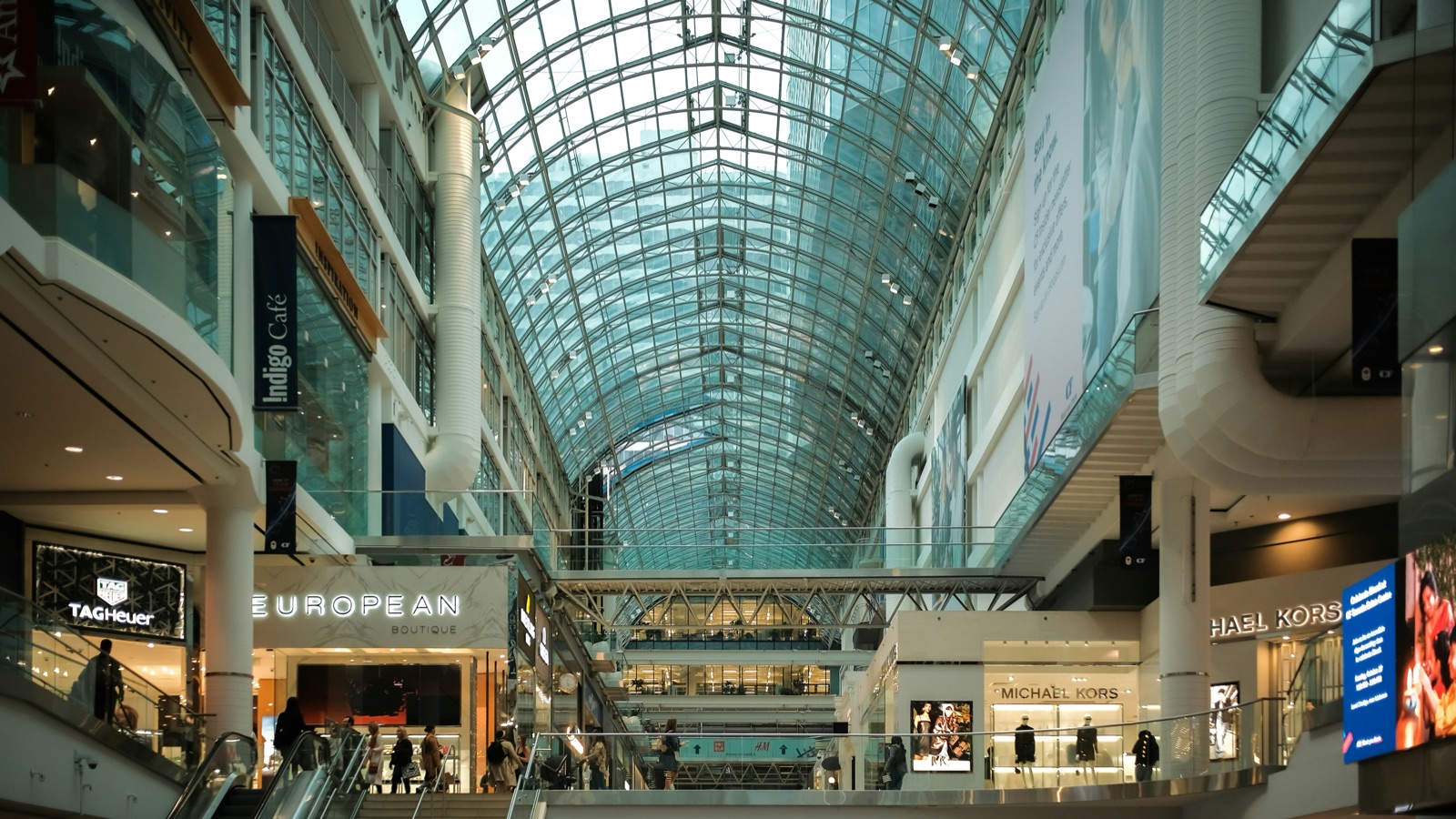 Multi-level shopping mall atrium with shoppers moving between floors