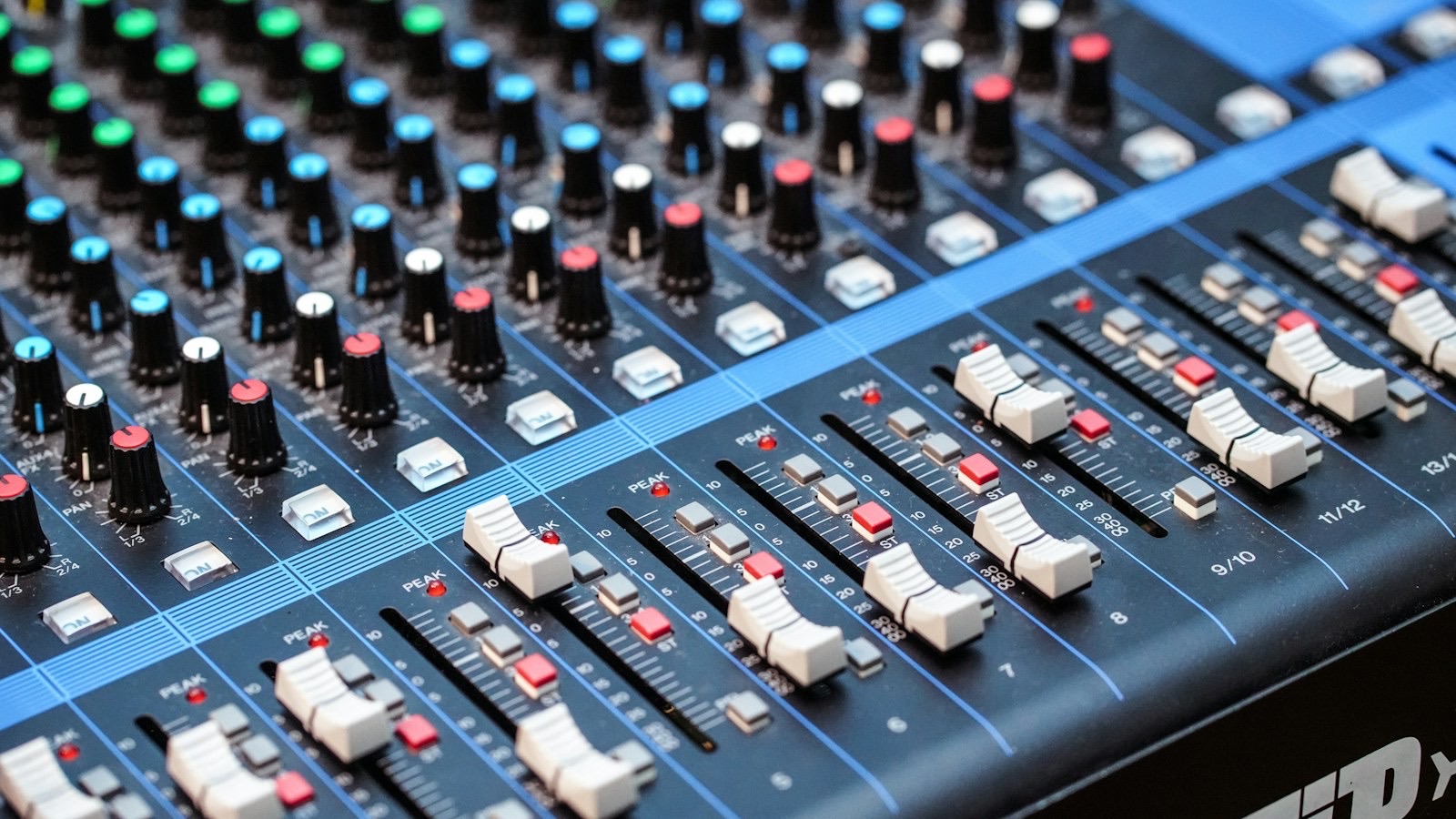 Close-up of faders and knobs on an audio mixing console